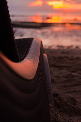 A selective focus of a beach lounge against a beautiful blurry sunset sky
