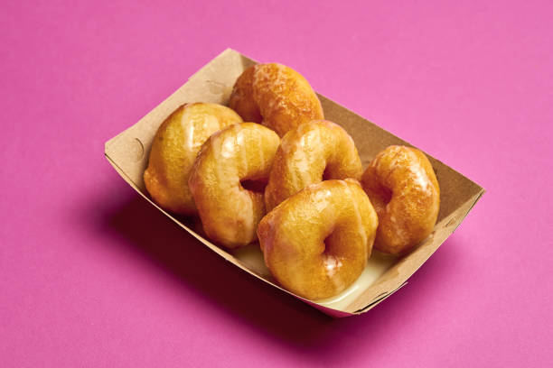 istock Fresh donuts with sweet sauce on a pink background. 1454780514