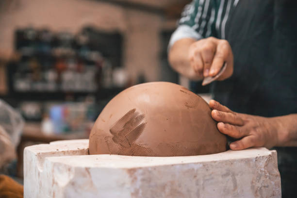istock Closeup of a person making a clay pot on the table in a workshop 1454780658