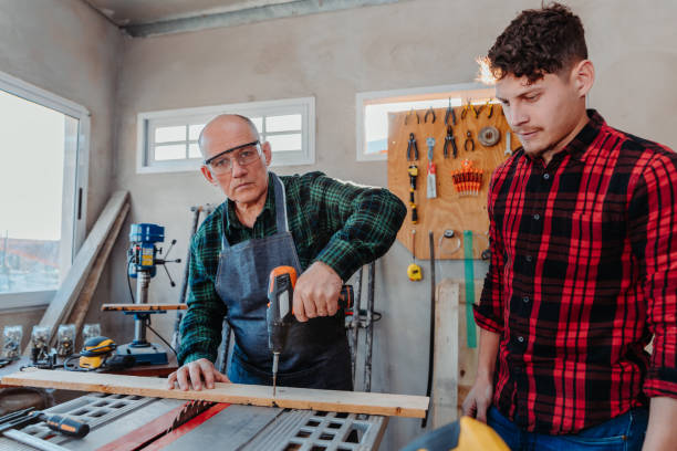 istock Senior carpenter teaching a younger man how to work 1454780833