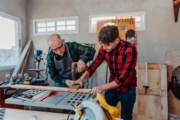 istock Senior carpenter teaching a younger man how to work 1454780839