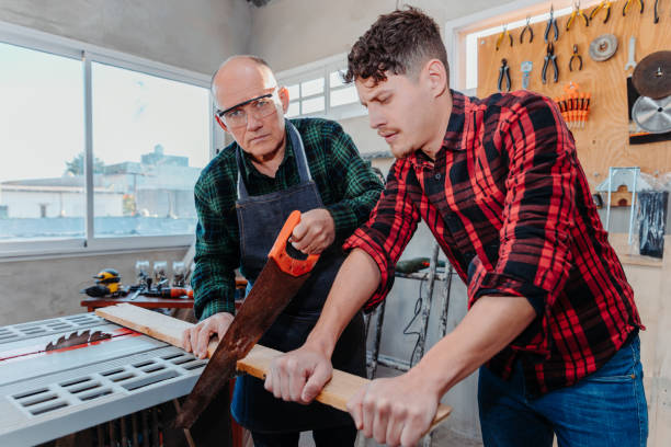 istock Senior carpenter teaching a younger man how to work 1454780858