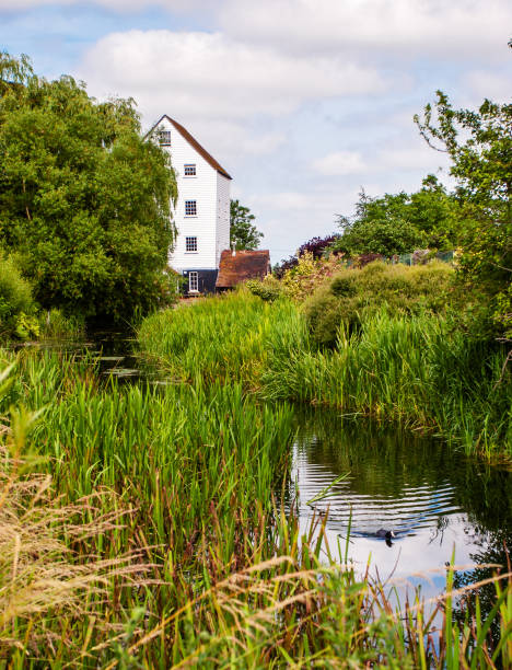 istock Cloudy sky over the river and rural building in summer 1454780930