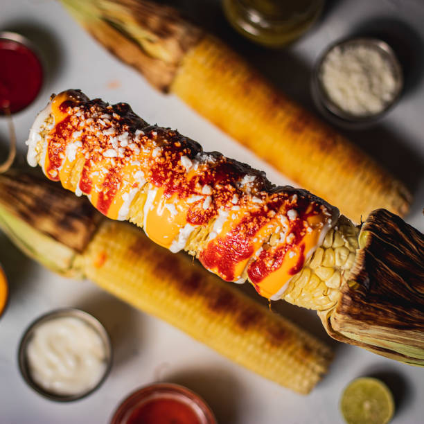 Vertical shot of delicious freshly cooked corn with sauces