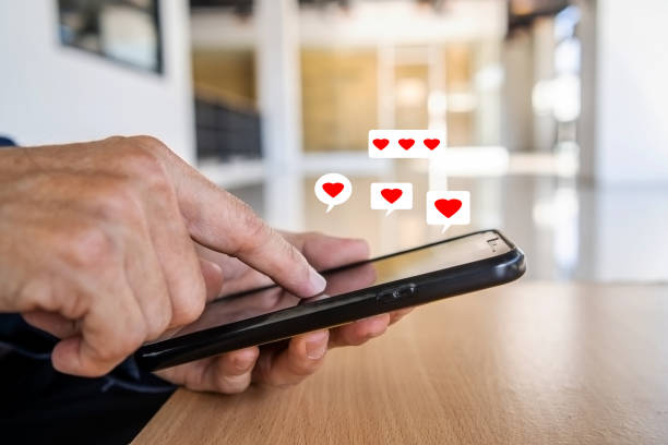 istock Man hand using smartphone with heart icon at office, He look message from lovers. 1454781573