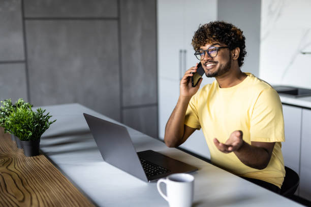 istock Indian man use notebook and phone work in the morning 1454781834