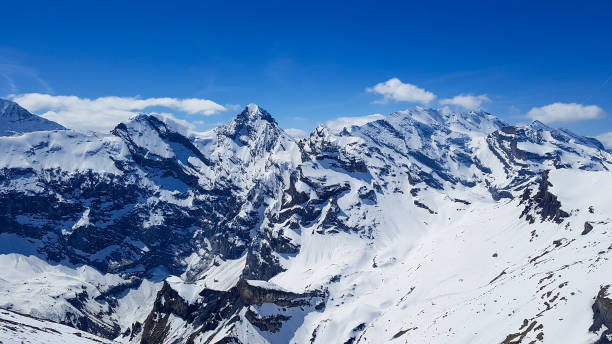 istock A snowy swiss mountain scene with bright blue sky 1454782347