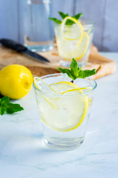 istock Vertical shot of a small cup of lemonade with ice and mint on a surface 1454782464