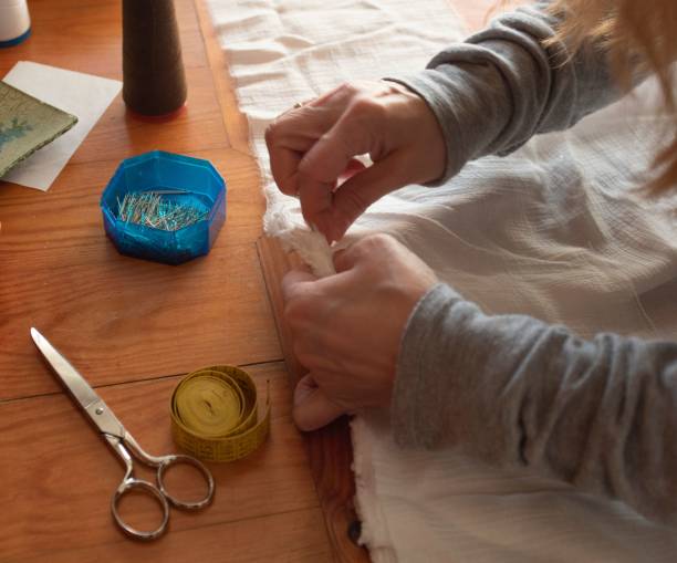 istock Female carefully sewing white cloth 1454783833