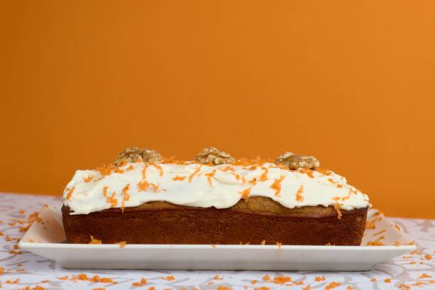 istock Carrot cake with almonds in a plate with orange wall on the back 1454785374