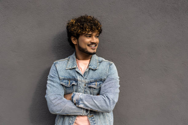 istock Handsome man with beard and crossed arms looking at camera. Middle eastern man isolated against grey wall and smiling. Satisfied indian guy looking at camera with a big laugh. 1454793001
