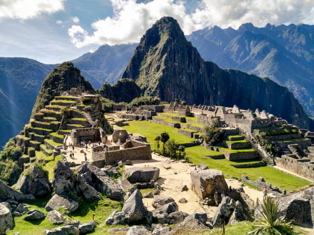 MACHU PICHU1 MAJESTIC LANDSCAPE OF MACHU PICHU WITH THE VAST MOUNTAINS SURROUNDING IT machu picchu on a sunny day stock pictures, royalty-free photos & images