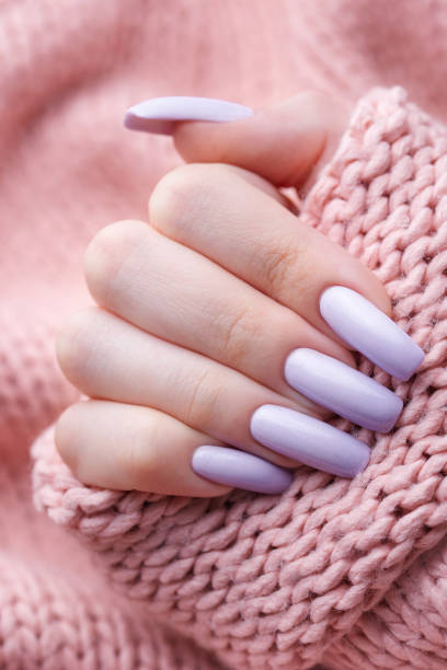 istock Girl's hands with a soft purple manicure. 1454794811