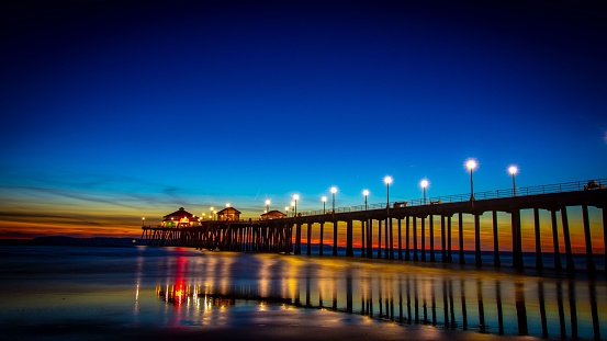 A fantastic view a bright sunset over an oceanside pier with lights