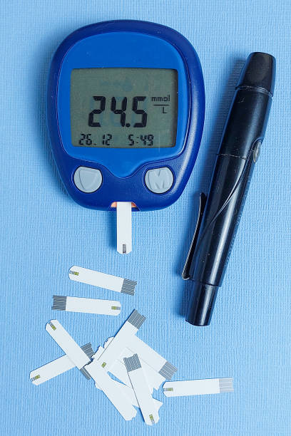 un medidor de glucosa en sangre con una lectura alta de azúcar en la sangre se encuentra sobre una mesa de madera. mediciones de azúcar en la sangre. el concepto de diabetes. espacio de copia de hiperglucemia. - hyperglycemia fotografías e imágenes de stock