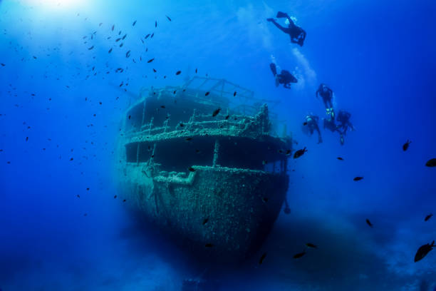 A group of unrecognizable divers explore a sunken shipwreck A group of unrecognizable divers explore a sunken shipwreck in the blue, mediterranean sea at Naxos island, Greece bottom the weaver stock pictures, royalty-free photos & images