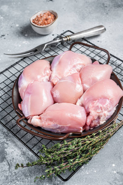 boneless and skinless raw chicken leg thigh fillet. gray background. top view - chicken thighs imagens e fotografias de stock