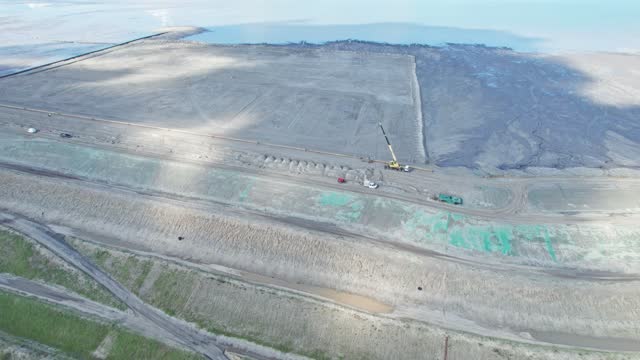 Aerial view of a sedimentation tank with industrial and mine waste. Contaminated mine water settling ponds. Sludge storage tank. Heavy vehicles working on the sludge tank. Version 12