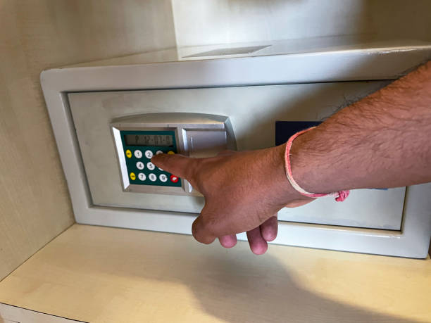 istock Close-up image of unrecognisable person using keypad on hotel electronic hotel wardrobe safe, opening safe deposit box for valuables and money, focus on foreground 1454802632