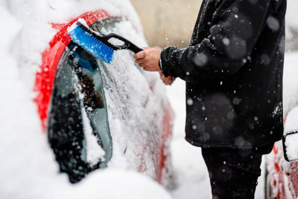 istock A Man is Cleaning a Snow From the Car with Brush. 1454803091