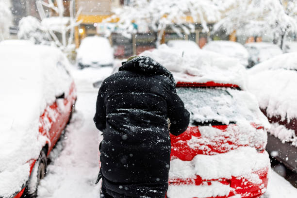 istock Man is Pushing a Car Stuck in Snow. 1454803623