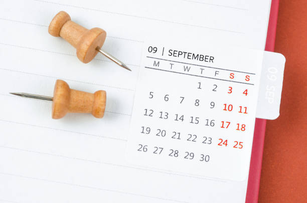 istock The Mini  September monthly calendar and wooden push pin on open diary. 1454803724