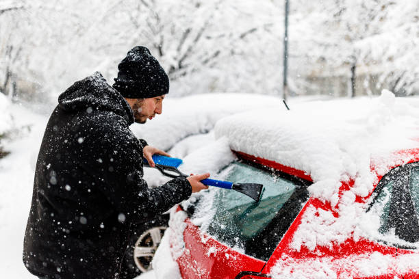istock A Young Man is Cleaning Ice and Snow from a Car Windshield. 1454803739