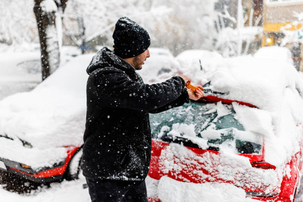 istock A Man has Snow Problems with a Car so he is Shoveling it. 1454803796