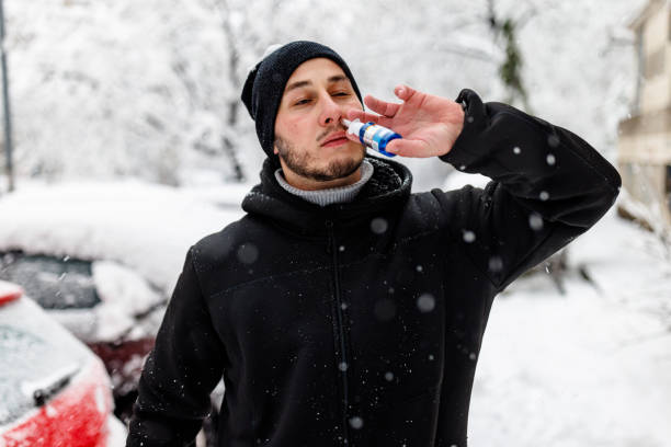 istock Young Man is Putting a Nasal Spray During a Winter Day. 1454803874