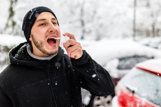 istock Young Man with Asthma is Using Inhaler During a Winter Day. 1454803890
