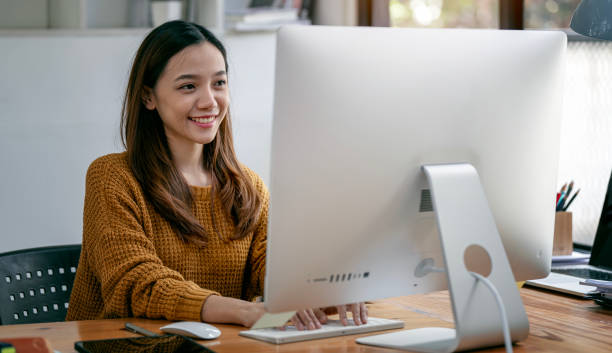 istock Portrait of Beautiful Asian freelancer Using Desktop Computer at home office. 1454803981
