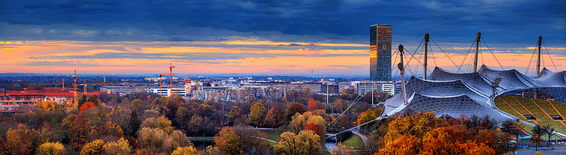 Autumn cityscape, panorama, banner - view of Munich at sunset from the Olympiapark or Olympic Park, Oberwiesenfeld neighborhood, Munich, Bavaria, Germany, 14 November, 2022
