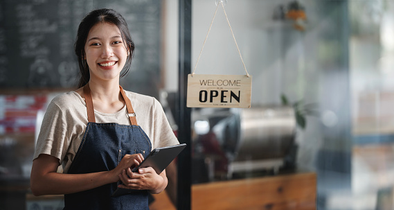 Startup successful small business owner sme beauty girl stand with tablet in her coffee shop. Portrait of asian woman barista cafe owner. SME entrepreneur business concept