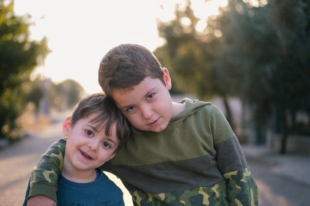 Two brothers are hugging in a park, showing their love and affection