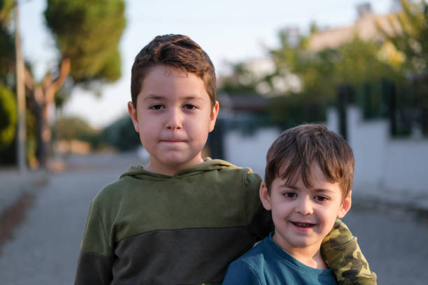 Child boy greeting friend outdoors