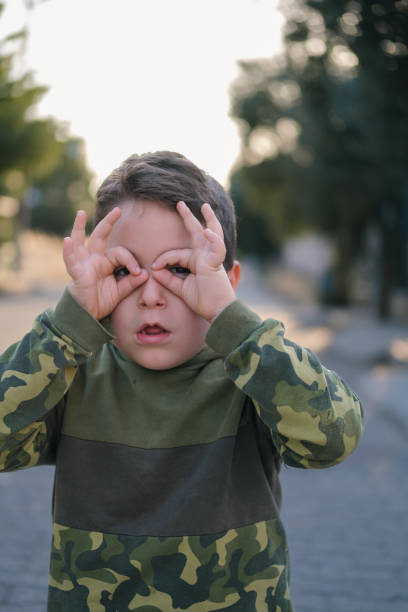 Funny little boy making glasses with his hands.