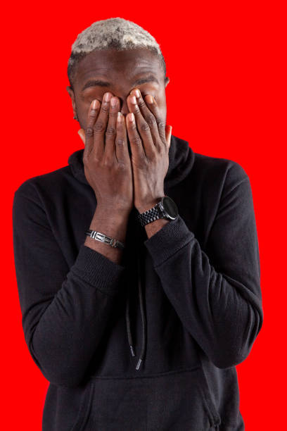 istock Portrait of young man with hands on face 1454807797