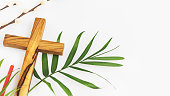 Wooden crucifixion, palm leaf, willow branch and red church candle