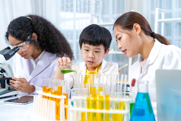 istock smart young boy enjoys examining chemical laboratory with school teacher assistant 1454809740