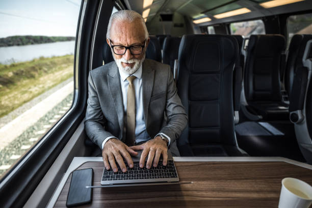 istock High angle view of professional businessman working on laptop while sitting on subway or intercity train 1454814936