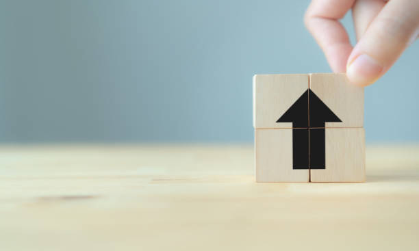 istock Black arrow points up sign on wooden cube block and copy space. 
Breakthrough and progress concept. Increasing of business performance, productivity, efficiency , investment, value added, pricing. 1454817012