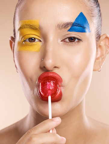 Beauty paint, face art and woman with creative makeup design, skincare or luxury facial cosmetics. Color creativity, lollipop and portrait of aesthetic model girl with red, blue and yellow shapes