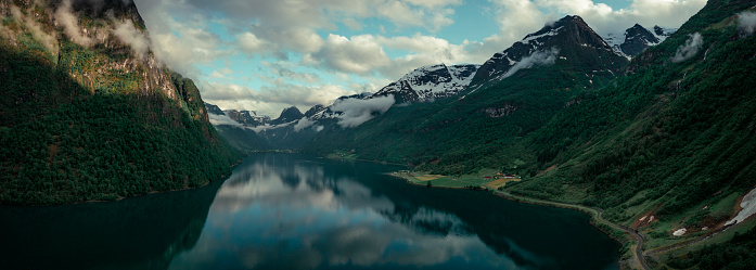 Aerial view of landscape panorama of fjord at Briksdalsbreen glacier in Jostedalsbreen mountains during summer, clouds in blue sky