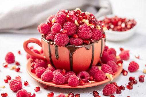 Raspberry mug cake in a red ceramic mug on white background
