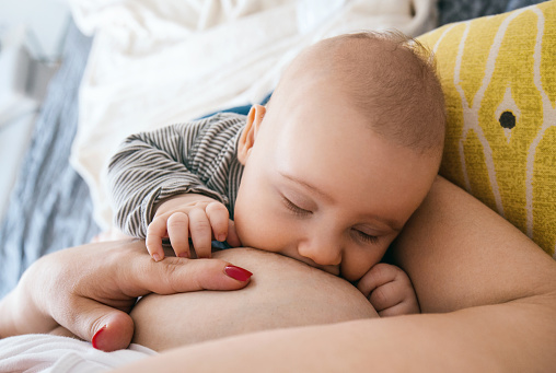 High angle view of unrecognizable woman breastfeeding her child.