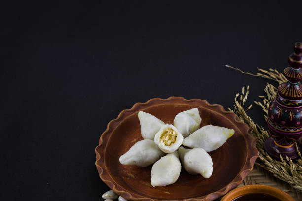 istock puli pithe or bengali rice flour dumplings with coconut fillings served on a clay plate with jaggery. shot against black background.this traditional dish made during poush sankranti or makar sankranti 1454829756