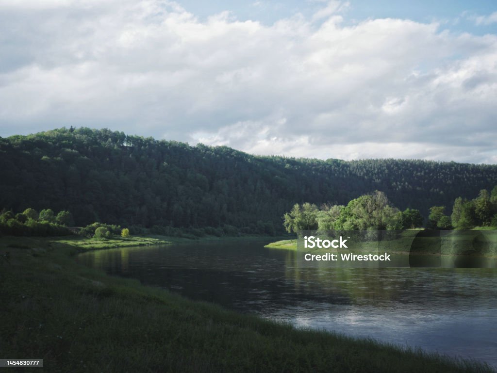 the Elbe flows through the green summer landscape i die Elbe vor einem Berg in der saechsich-boehmischen Schweiz Bohemian Switzerland Stock Photo