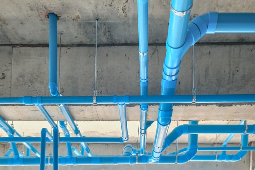 A low angle shot of industrial blue pipes on a ceiling