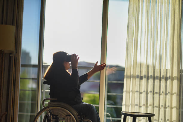 istock Woman in wheelchair using vr glasses at home 1454833441