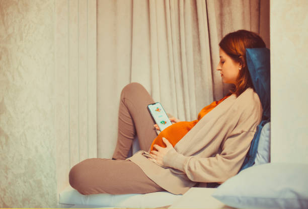 istock Pregnant woman holding smartphone using pregnancy tracker app 1454834614